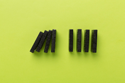 Black domino tiles on color background, top view