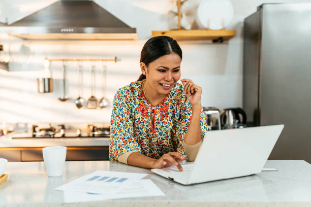 istock Asian businesswoman working at home on kitchen counter, using laptop and internet connection 1914601513