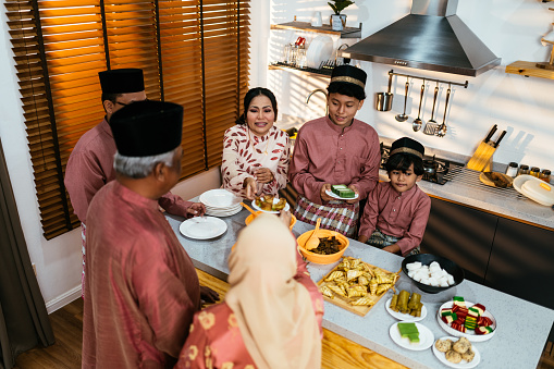 Muslim family celebrating Eid al-Fitr in hari raya attires