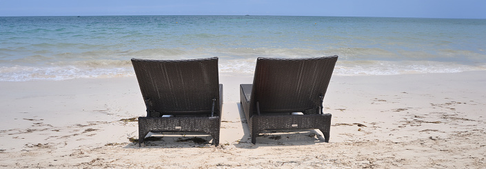 Panoramic view of two deck chairs at the beach in Antigua