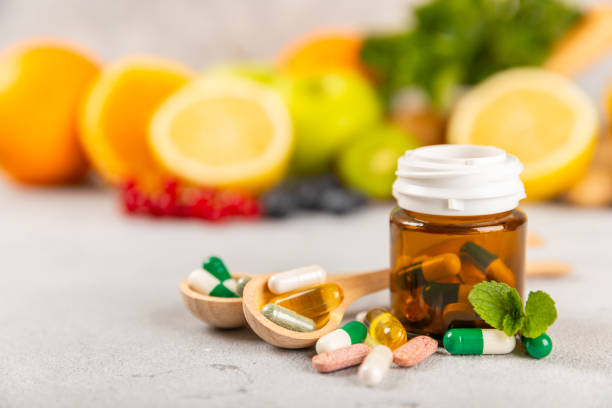 istock Vitamins and supplements. Variety of vitamin tablets on a textured background. Multivitamins with fresh and healthy fruits. Nutritional supplements. Flat layout. Place for text. Copy space 1914624519