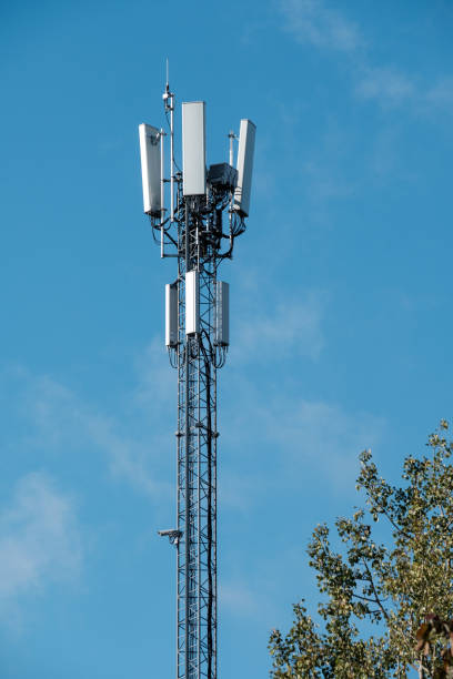Closeup of a modern communications tower with bright blue sky in the background. stock photo