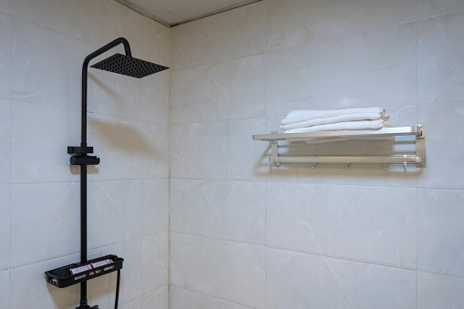 Bathtowels and shower showerheads on the hotel bathroom shelves