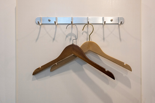 Hanging hangers on the hooks of the wall