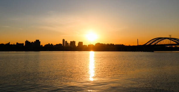 istock Scenery just before sunset - city skyline silhouette seen from the river 1914645801