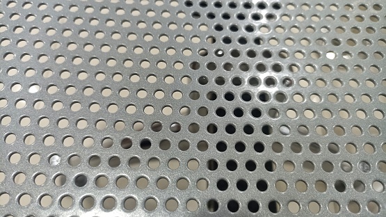 Stainless Steel with perforation. Texture Background of Metalic Silver Perforated Grid