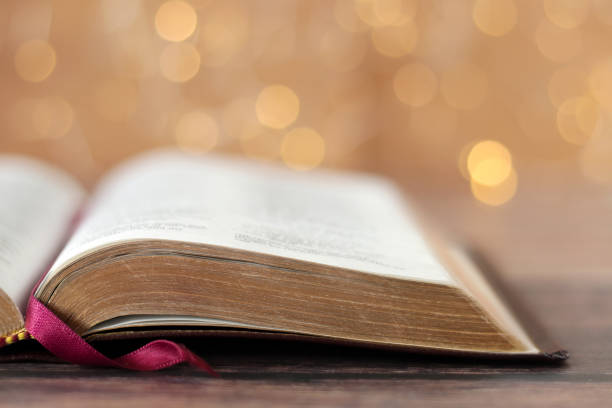 istock Open holy bible book with golden bokeh light background 1914672960