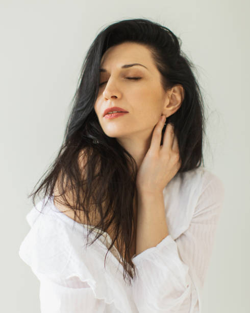istock Brunette woman in dress in studio on white background. 1914703904