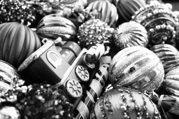 New Year's Christmas balls and decorations close up surface. Monochrome black white silver. Striped modern Christmas balls. Festive beautiful background. Xmas tinsel. Decorating home winter holidays.