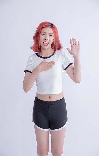 Young Asian woman with red hair wearing sportswear and smiling