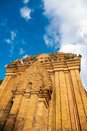 Looking up North Tower or Thap Chinh at about 28 meter high of Ponagar Cham Towers with terraced pyramidal roof, bricks under sunny blue clou sky, religious attractions in Nha Trang, Vietnam. Travel