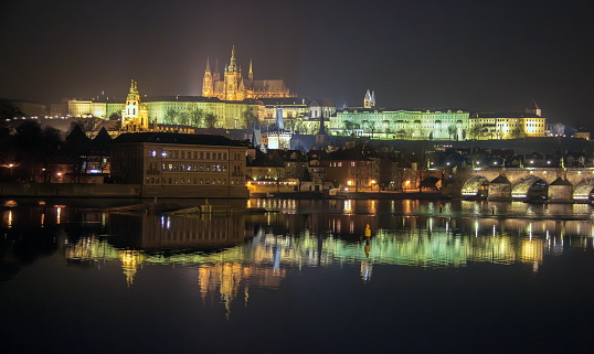 Night view of Prague with Charles Bridge,  Castle and St. Vitus Cathedral reflected on Vltava River, Prague, Czech Republic