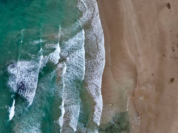 istock Tranquil beach scene featuring large waves crashing onto a rocky shoreline 1914827571