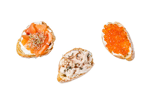 Bruschetta with Hot Smoked salmon, red caviar and herbs.  Isolated on white background, top view