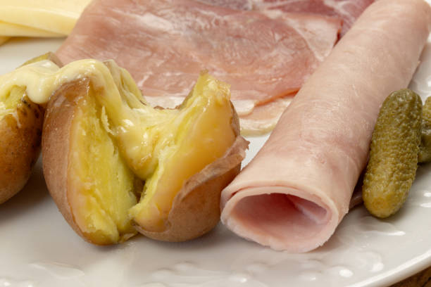 melted raclette cheese spread on a potato