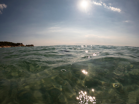 First person perspective of human legs splashing sea