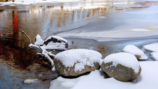 Snow covered rocks along a icy river
