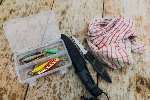 Aerial close-up view of fishing lures and knives with bag for fishing