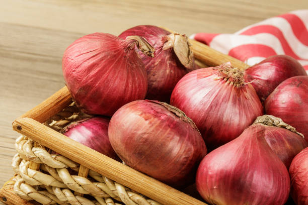istock Basket of Red Onions on  wooden background with copy space 1914969849