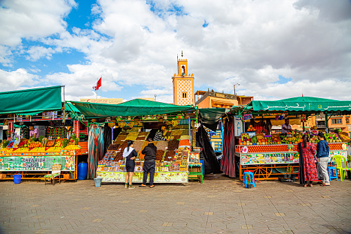 Marrakech,Morocco 17 May 2023:Food market at Djemaa el Fna Square with Mosque in the background
