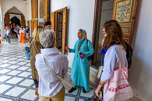 Marrakech,Morocco 18 May 2023:Tour guide explains to tourists about Marrakech in Le Palais Bahia