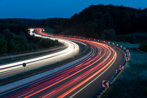 Long exposure of car lights on motorway meandering through Hills in Bavaria, Germany.