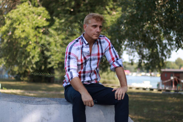 istock Portrait of mature blonde man while sitting on wall 1914991468