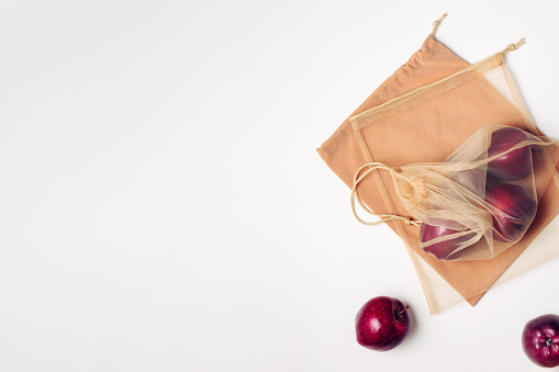 Red apples in a reusable mesh bag. Zero waste concept, copy space.