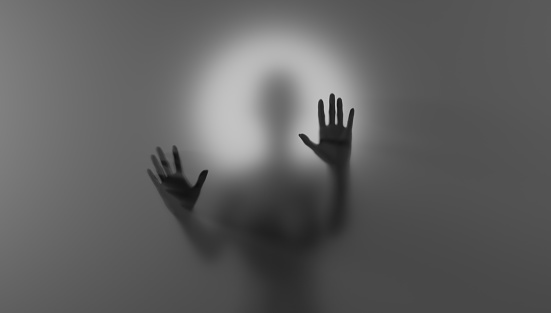 Blurred silhouette behind matte glass. Creepy Halloween concept