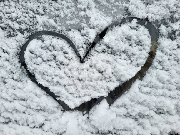 istock Heart drawn on a car windshield covered with fresh Christmas snow. 1915053261