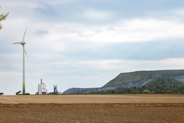 A wind generator in a field next to a dump of empty mine rocks
