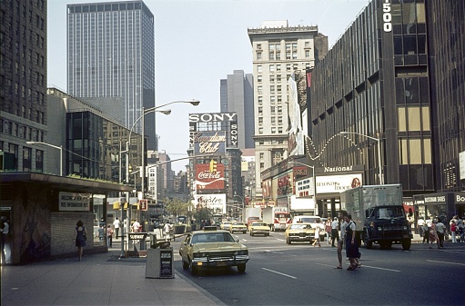 New York City, NY, USA, 1975. City view with buildings, New Yorkers, traffic and advertising signs at Times Square in downtown Manhattan.