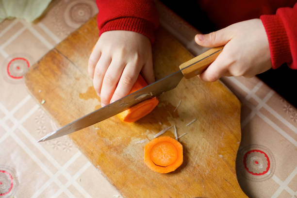 istock A child cuts carrots. Child labor. Self-cooking. 1915095261