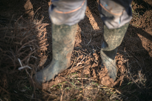 Man with dirty boots in agricultural field