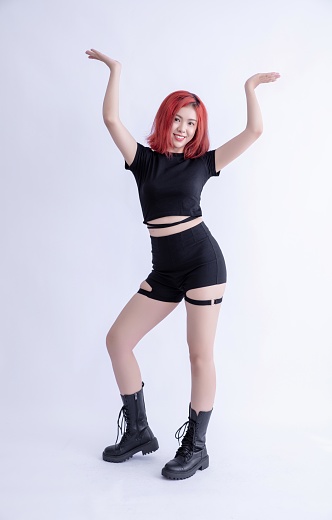 Redhead woman in black outfit dancing,