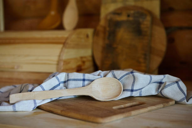 istock Rustic kitchen items. Wooden spoon and towel on the kitchen table in a log house 1915125145
