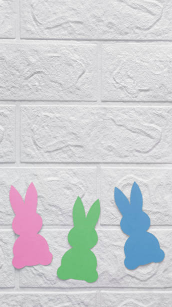istock Paper decoration in shape rabbits. Vertical photo. Place for text. 1915207547