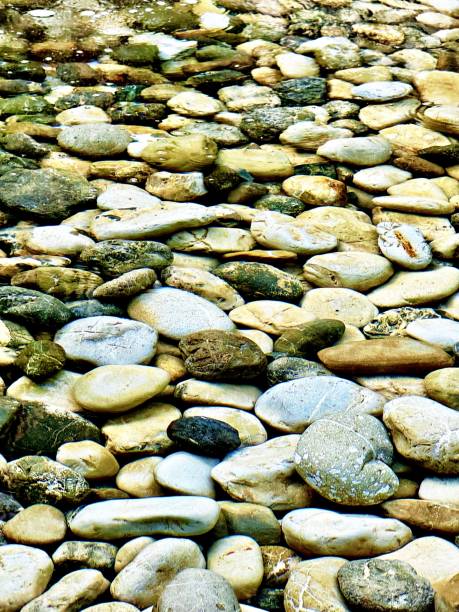 A rock bottom river bed and the smooth river water flowing steadily
