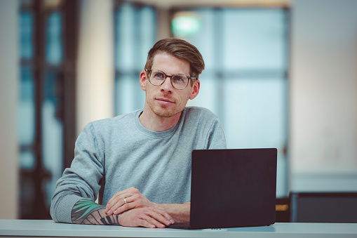 Businessman holding a briefcase in office, white copy space