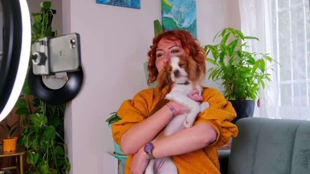 Excited influencer doing a vlog post in her living room with her dog