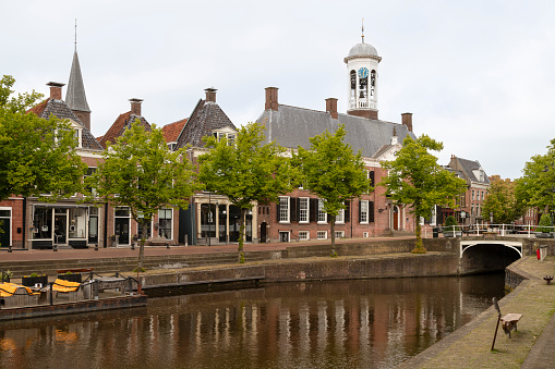 Historic canal houses and the town hall in the center of the picturesque town of Dokkum in Friesland.