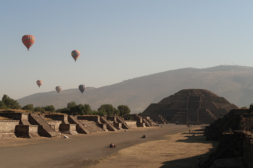 View onto the Avenue of the Dead/Calzada de Los Muertos towards the Pyramid of the Moon in the early morning, hot air balloons still visible, Teotihuacan, Mexico City 2022