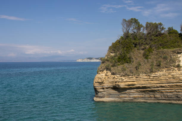 Crystal-clear seawater gently washes over a rocky shoreline, revealing the underwater textures and creating a serene coastal scene. A peaceful moment by the sea.