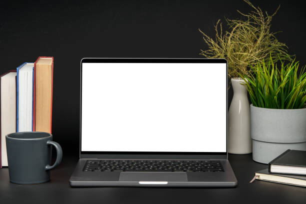 istock Laptop with blank screen on table against black background 1915335289