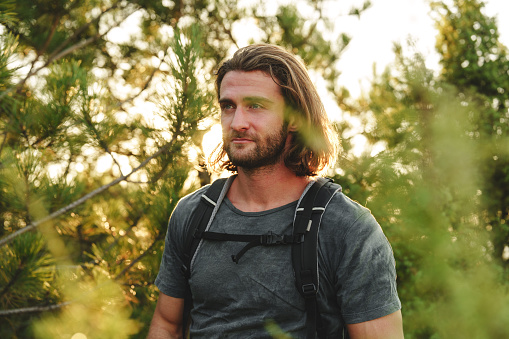 Portrait of hiker man with backpack trekking in the mountains close up