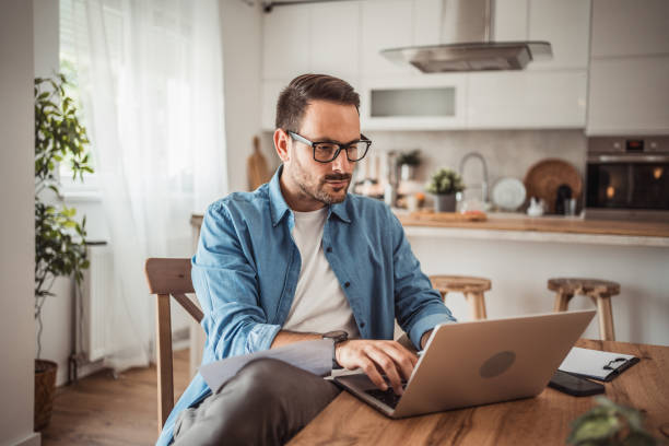 istock Photo of a young man working at home using modern technologies 1915377785