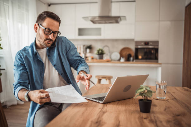 istock Photo of a young man working at home using modern technologies 1915378316