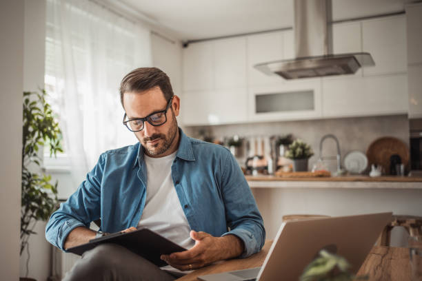 istock Photo of a young man working at home using modern technologies 1915379907