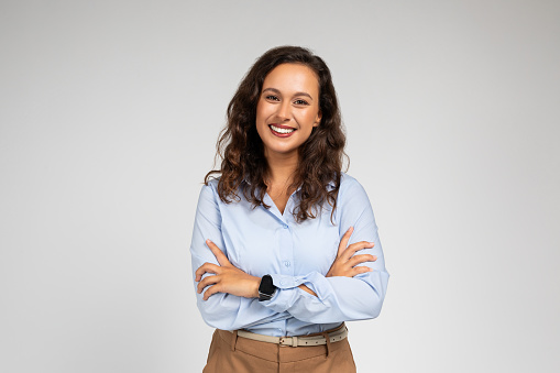 Smiling friendly confident millennial caucasian lady manager, teacher in formal wear with crossed arms on chest, isolated on gray background studio background. Work, study, courses and business