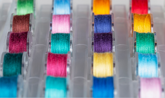 Plastic bobbins for a sewing machine with multi-colored threads.